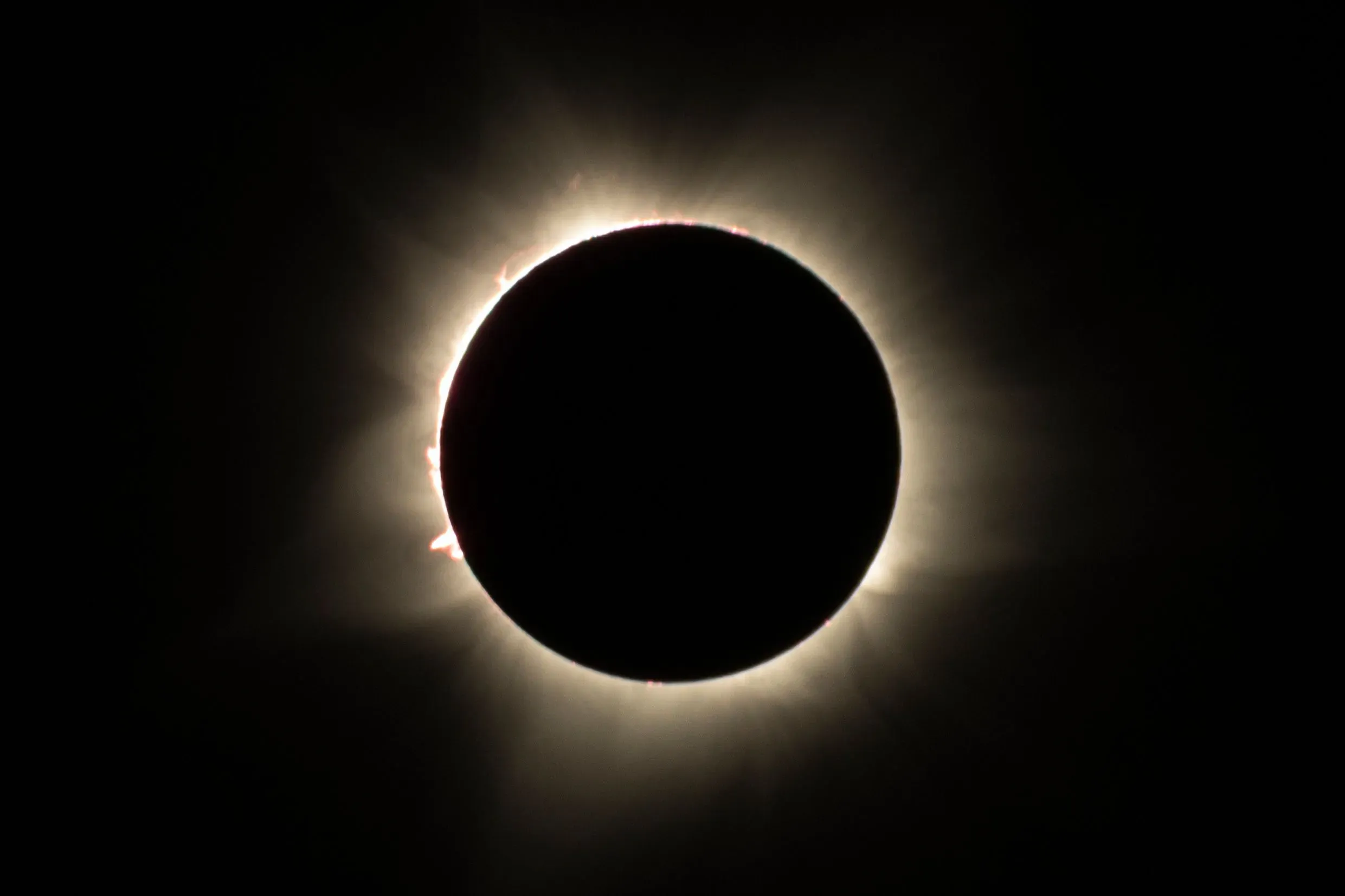 Almyrkvi á sólu þar sem tunglið hylur sólina og sólkórónan sést sem ljós hjúpur umhverfis tunglið.